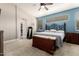 Comfortable bedroom with blue accent wall, large window, ceiling fan, and doorway to walk-in closet at 6862 W Honeysuckle Dr, Peoria, AZ 85383
