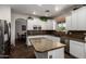 Clean kitchen with stainless steel appliances, white cabinets, hardwood flooring, and a center island at 6862 W Honeysuckle Dr, Peoria, AZ 85383