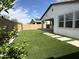 This backyard features artificial grass, a concrete patio, and an overhang at 6947 W Spur Dr, Peoria, AZ 85383