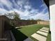 The backyard features green turf grass with mature trees, brick walls and a stepping stone walkway at 6947 W Spur Dr, Peoria, AZ 85383