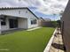 Well-maintained backyard with artificial turf, a covered patio, and stepping stones at 6947 W Spur Dr, Peoria, AZ 85383