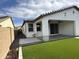 This backyard features artificial grass, a concrete patio, and an overhang at 6947 W Spur Dr, Peoria, AZ 85383