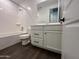 Bright bathroom featuring white cabinets, wood-look flooring, and a shower-tub combo at 6947 W Spur Dr, Peoria, AZ 85383