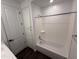 Bathroom featuring shower-tub combo, built-in linen storage, and white cabinets at 6947 W Spur Dr, Peoria, AZ 85383