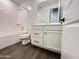 Bright bathroom featuring white cabinets, wood-look flooring, and a shower-tub combo at 6947 W Spur Dr, Peoria, AZ 85383