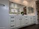 Bathroom vanity with double sinks, expansive mirror, and ample storage in white cabinets at 6947 W Spur Dr, Peoria, AZ 85383