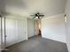 This bedroom features neutral walls, carpet, a ceiling fan, and a closet with panel doors at 6947 W Spur Dr, Peoria, AZ 85383