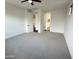Spacious carpeted primary bedroom featuring a ceiling fan and a doorway to the bathroom at 6947 W Spur Dr, Peoria, AZ 85383