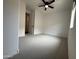 Spacious bedroom with neutral carpet, ceiling fan, and a walk-in closet at 6947 W Spur Dr, Peoria, AZ 85383