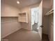Walk-in closet with carpet, wooden clothes racks and shelving, with a doorway to the bathroom at 6947 W Spur Dr, Peoria, AZ 85383