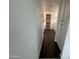 Hallway with tile floors leading to Primary bath with bright vanity and glass shower at 6947 W Spur Dr, Peoria, AZ 85383