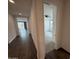Hallway with wood floors leading to a bedroom with a ceiling fan and natural light at 6947 W Spur Dr, Peoria, AZ 85383