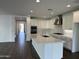 Modern kitchen with quartz counters, stainless appliances, and hardwood flooring in open concept layout at 6947 W Spur Dr, Peoria, AZ 85383