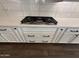 Kitchen cooktop with white cabinets and drawers, perfect for culinary enthusiasts at 6947 W Spur Dr, Peoria, AZ 85383