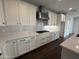 Modern kitchen with white cabinets, subway tile backsplash, and a stainless steel hood at 6947 W Spur Dr, Peoria, AZ 85383