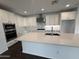Kitchen island with quartz countertops, stainless steel appliances, and white cabinetry at 6947 W Spur Dr, Peoria, AZ 85383
