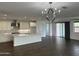 Elegant living space boasts hardwood floors, a modern chandelier, and a gourmet kitchen view at 6947 W Spur Dr, Peoria, AZ 85383