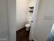 Modern powder room boasts dark wood floors, floating shelves, and contemporary toilet fixture at 6947 W Spur Dr, Peoria, AZ 85383