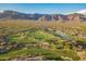 Stunning aerial view of a golf course community, featuring lush greens, water features, and mountain views at 7710 E Golden Eagle Cir, Gold Canyon, AZ 85118