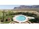 Aerial view of a community pool with lounge chairs, lush landscaping, and mountain views at 7710 E Golden Eagle Cir, Gold Canyon, AZ 85118