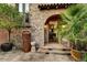 Inviting courtyard with stone accents, lush plants, and an arched entryway to the home at 7710 E Golden Eagle Cir, Gold Canyon, AZ 85118