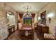 Formal dining room with a stone accent wall, elegant chandelier, and tile flooring at 7710 E Golden Eagle Cir, Gold Canyon, AZ 85118