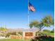 Community entrance sign featuring the American flag, set against the backdrop of the Superstition Mountains at 7710 E Golden Eagle Cir, Gold Canyon, AZ 85118