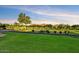 Lush green golf course with manicured lawns, mature trees, and distant mountain views under a bright, partly cloudy sky at 7710 E Golden Eagle Cir, Gold Canyon, AZ 85118