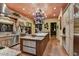 Open kitchen featuring an island with seating, stainless steel appliances, custom cabinets, and stone tile flooring at 7710 E Golden Eagle Cir, Gold Canyon, AZ 85118