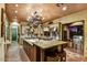 Spacious kitchen with a large island, bar seating, stone tile flooring, stainless steel appliances, and hanging pot rack at 7710 E Golden Eagle Cir, Gold Canyon, AZ 85118