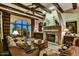 Cozy living room featuring wood beam ceilings, a stone fireplace, and a large window with garden views at 7710 E Golden Eagle Cir, Gold Canyon, AZ 85118