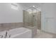 An elegant bathroom features a soaking tub and a separate glass-enclosed shower at 8817 W Denton Ln, Glendale, AZ 85305