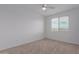 Bright bedroom with neutral carpet, a ceiling fan, and two windows at 8817 W Denton Ln, Glendale, AZ 85305