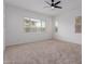 Bright bedroom with neutral carpet, ceiling fan, and multiple windows at 8817 W Denton Ln, Glendale, AZ 85305