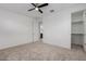 Bedroom featuring carpet, ceiling fan, and access to a closet and bathroom at 8817 W Denton Ln, Glendale, AZ 85305