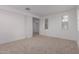 A spacious bedroom boasts neutral carpet and a nearby doorway to another room at 8817 W Denton Ln, Glendale, AZ 85305