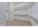 A spacious walk-in closet with wall-mounted shelves and clothing rods for storage at 8817 W Denton Ln, Glendale, AZ 85305