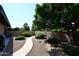 A winding pathway in a backyard with gravel, stone and mature trees at 9419 E Riviera Dr, Scottsdale, AZ 85260