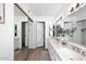 Bright bathroom with double sinks, granite countertops, and large framed mirror at 9419 E Riviera Dr, Scottsdale, AZ 85260