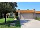 Home exterior showcasing a clay tile roof, green lawn, and a two-car garage at 9419 E Riviera Dr, Scottsdale, AZ 85260