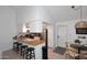 Bright kitchen features a wooden breakfast bar with modern stools and stainless steel appliances at 9419 E Riviera Dr, Scottsdale, AZ 85260