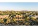 An aerial view of a luxury home nestled in the desert landscape with mature vegetation and mountain views at 9894 E Miramonte Dr, Scottsdale, AZ 85262