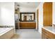 Bright bathroom featuring double vanity, granite countertops, glass enclosed shower, and a white bathtub at 9894 E Miramonte Dr, Scottsdale, AZ 85262