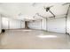 Spacious three car garage featuring epoxy floors, storage cabinets, and multiple doors at 9894 E Miramonte Dr, Scottsdale, AZ 85262