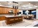 Modern kitchen featuring wood cabinets, large island with seating, and stainless steel appliances and an adjacent dining area at 9894 E Miramonte Dr, Scottsdale, AZ 85262