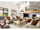 Inviting living room with a stone fireplace, comfortable seating, and views of the surrounding landscape at 9894 E Miramonte Dr, Scottsdale, AZ 85262
