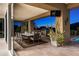 Charming outdoor patio with a large dining table and built in grill with a view to the pool and desert landscape at 9894 E Miramonte Dr, Scottsdale, AZ 85262