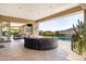 Expansive covered patio with comfortable seating, bar, and dining area overlooking pool and desert views at 9894 E Miramonte Dr, Scottsdale, AZ 85262