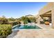 Sparkling pool with travertine patio, desert plants, and outdoor dining area create a relaxing backyard retreat at 9894 E Miramonte Dr, Scottsdale, AZ 85262
