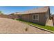 View of home's backyard showcasing artificial turf, rock landscaping, privacy walls, and a covered patio at 10502 W Bronco Trl, Peoria, AZ 85383